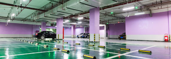 This image shows a commercial parking area that has a green epoxy color and white lines.