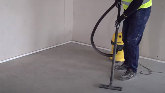 This image shows a woman using a vacuum to clean a floor.